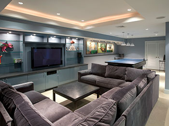 Game-Room-blue-cabinets-blue-walls-cove-lighting-flat-panel-cabinets-flat-screen-tv-game-room-glass-shelves-louvered-door-party-room-pendan